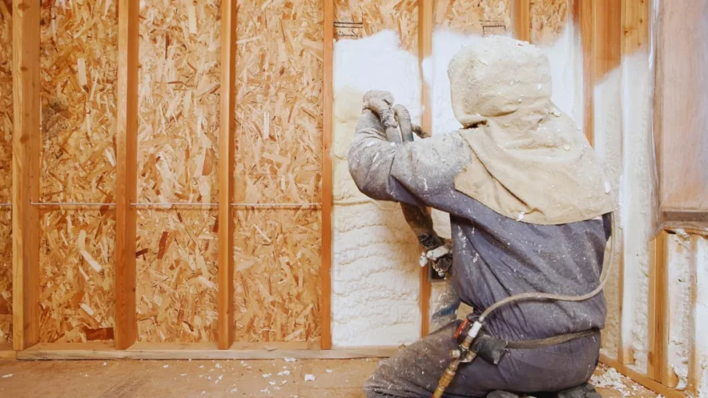 Vakman brengt isolatieschuim aan in de spouwmuur van een woning voor betere thermische isolatie.